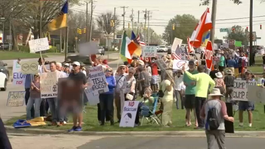 Cientos se recolectan fuera de la tienda Raleigh Tesla para la protesta de Elon Musk