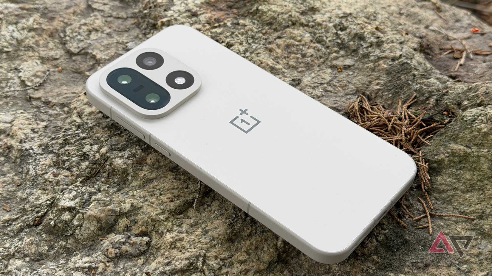 OnePlus 15 sentado boca abajo contra una roca