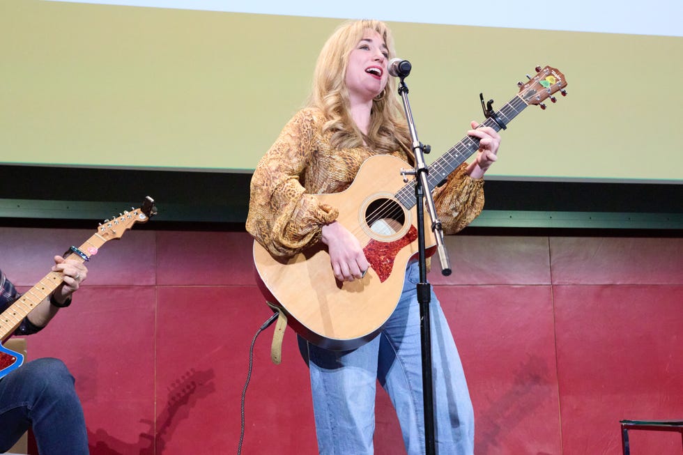 Músico en el escenario con una guitarra acústica.
