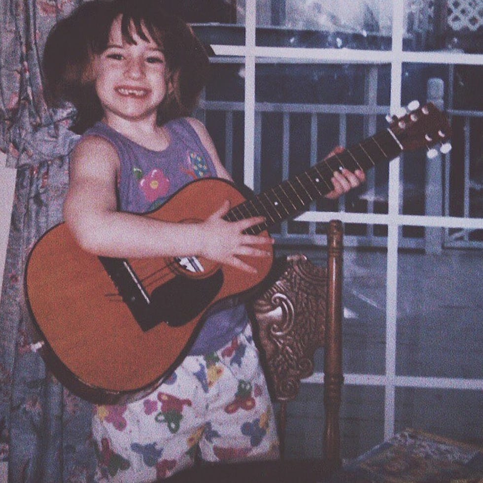Niño sosteniendo una guitarra dentro
