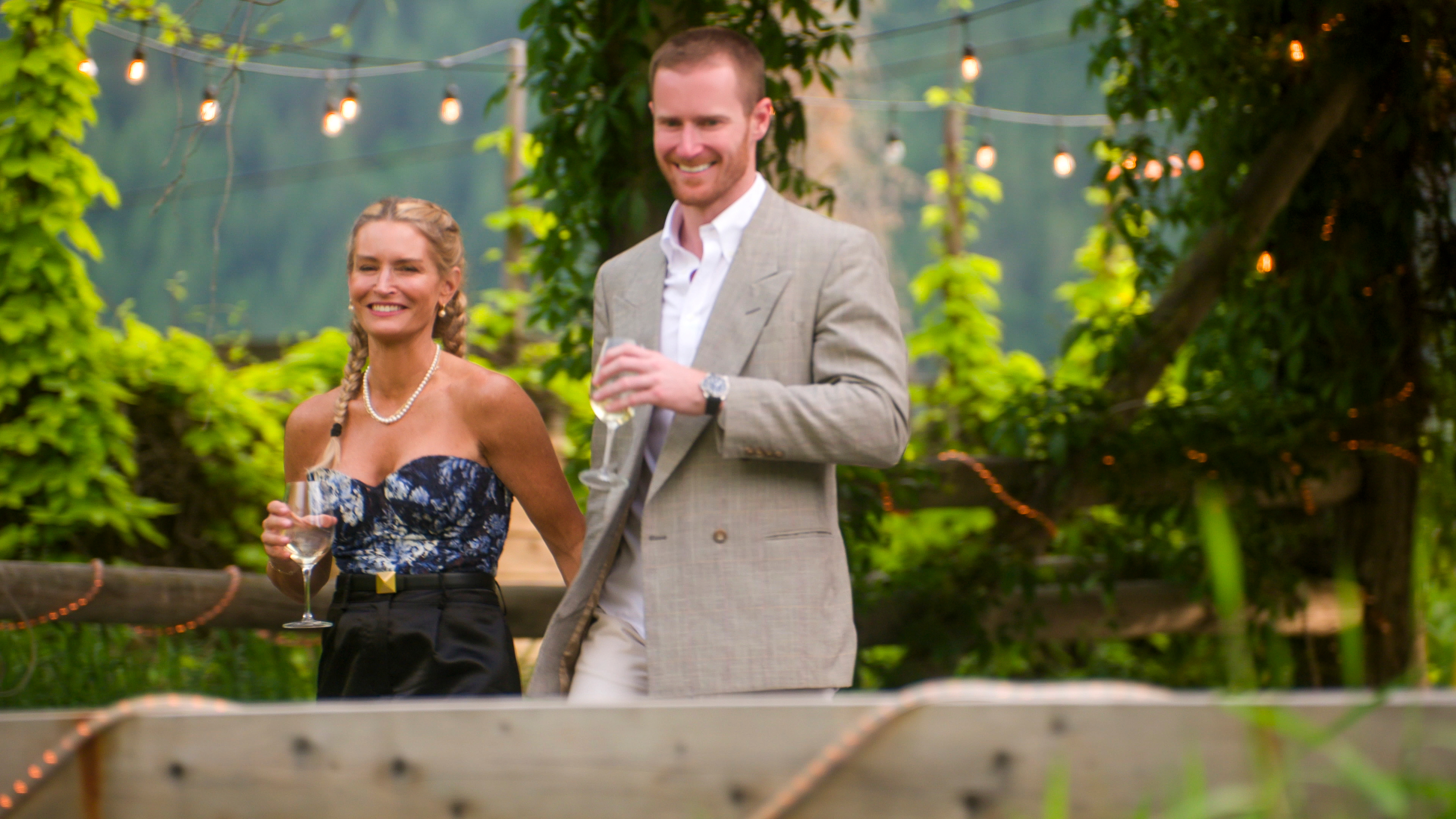 Theresa Demaria y John Merrill vestidos con atuendo formal llegando a una bodega en el primer episodio de La era de la atracción.